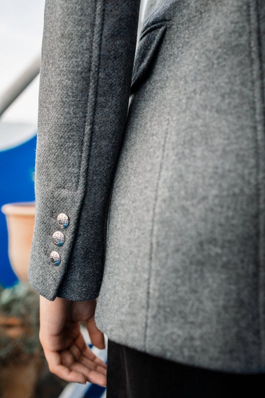 Détails de la doublure boutonnée d'un manteau gris.