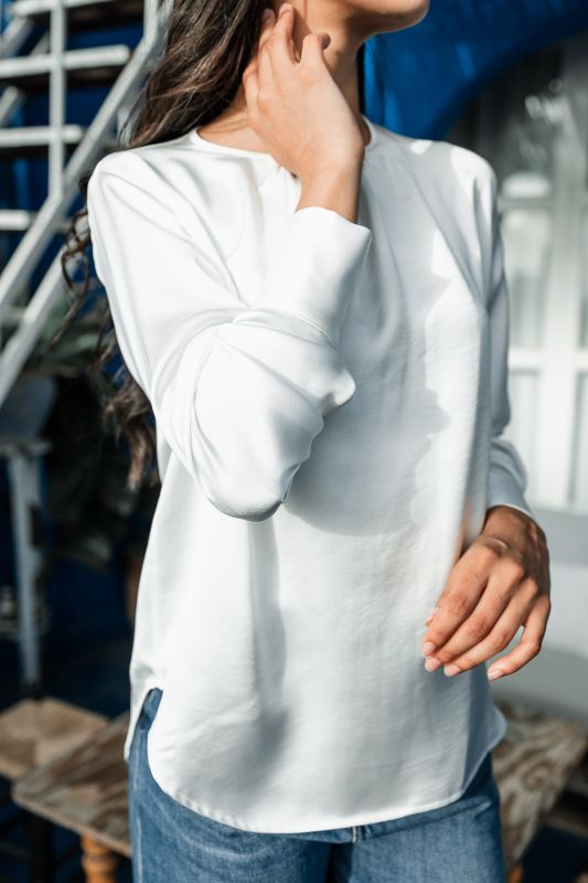 Détails de la blouse blanche pour femme montrant sa simplicité élégante.