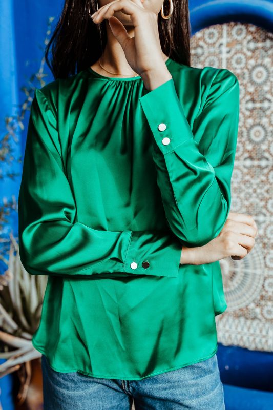 Détail raffiné de la blouse verte.
