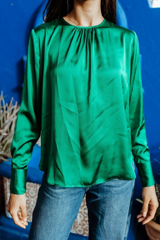 Détails de la blouse verte pour femme montrant sa simplicité élégante.