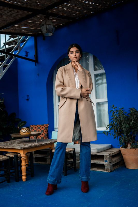 Un manteau beige agrémenté d'un bouton, une touche de style subtile.