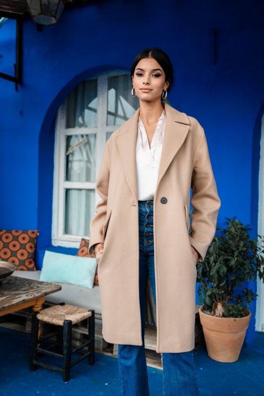 Un manteau beige élégant, mis en valeur par un bouton.