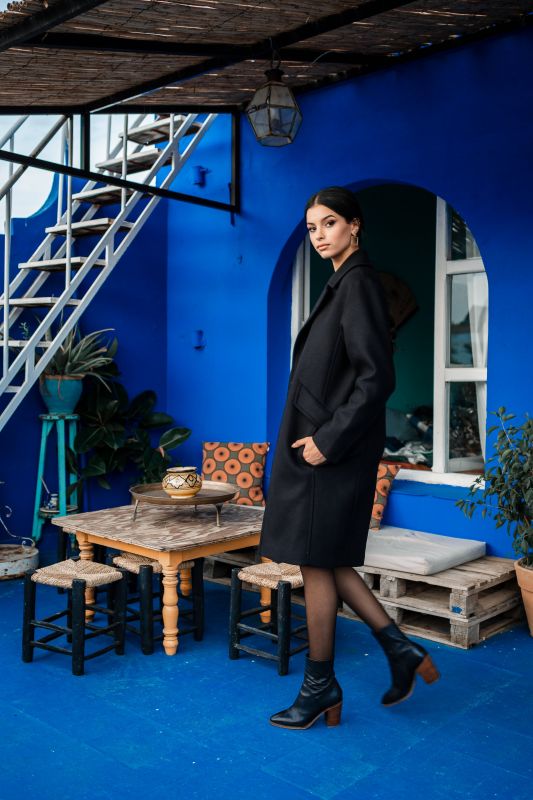 Un élégant manteau noir, accentué par un unique bouton.
