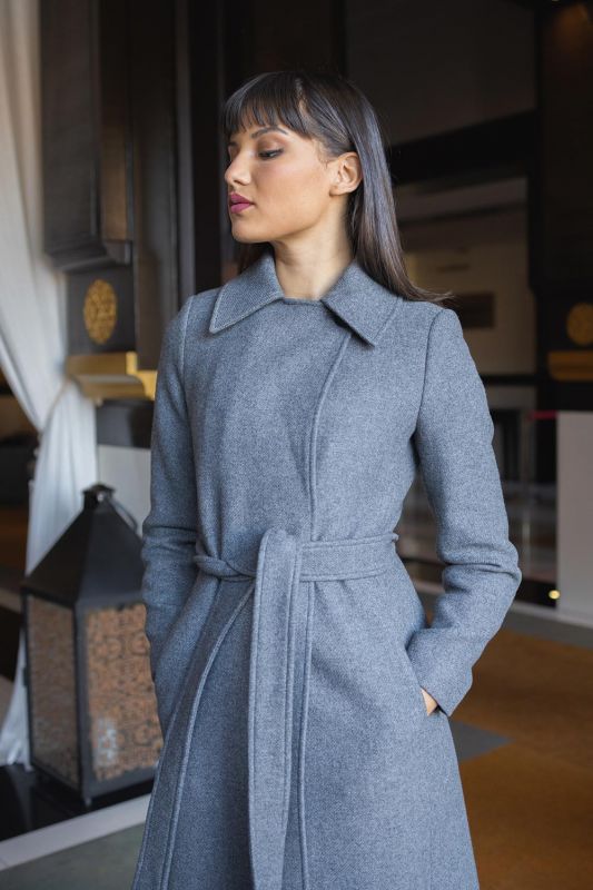 Manteau gris agrémenté d'une ceinture grise, une touche moderne.