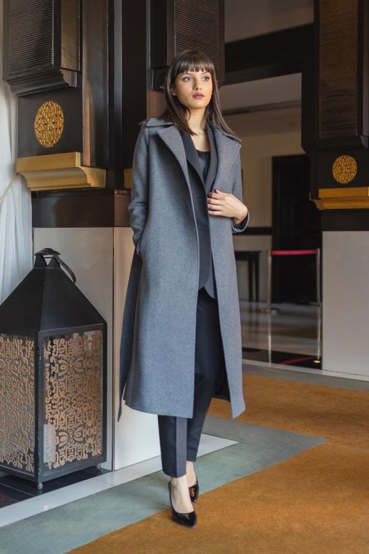 Détails du manteau gris avec ceinture.