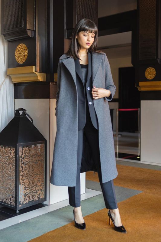 Un manteau gris avec ceinture assortie, pour un style sophistiqué.