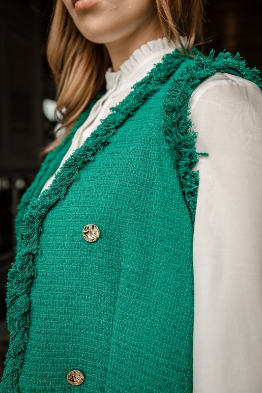 Détails du gilet : Couleur verte et design raffiné.