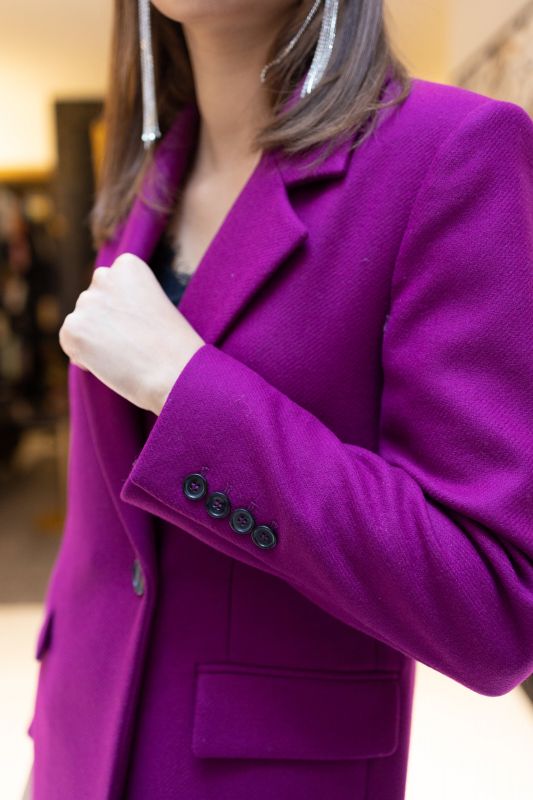 Détails du manteau framboise à bouton unique.