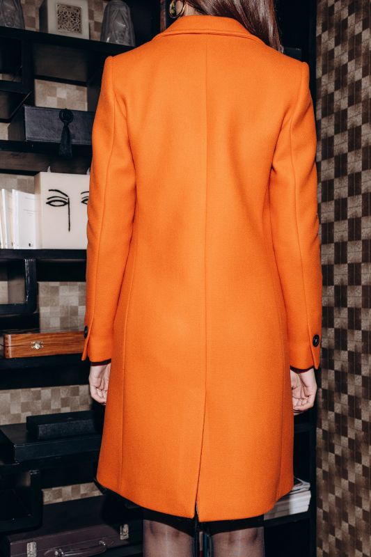 Détails du manteau orange, une couleur qui attire l'attention.