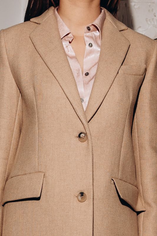 Détails du manteau blanc cassé à deux boutons, une pièce raffinée.