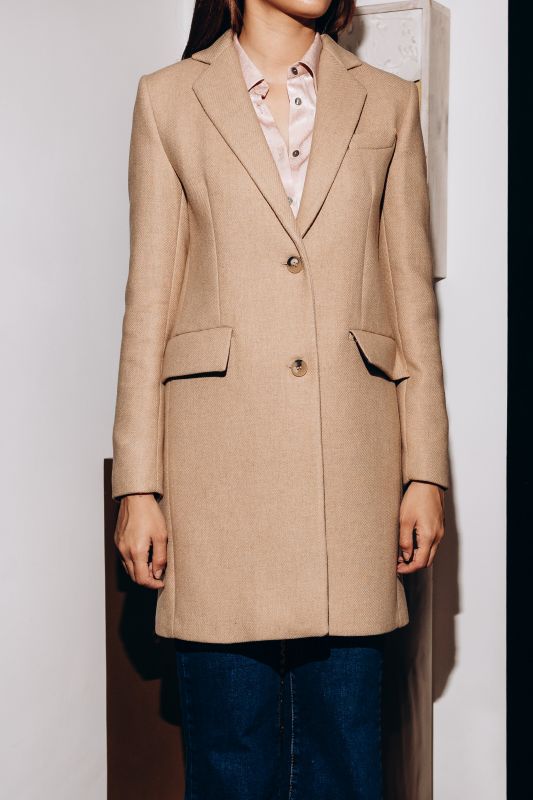 Manteau Rome de la collection tweed en beige, design long et chic avec deux boutons.