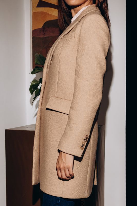 Détails du manteau blanc cassé à deux boutons, une pièce raffinée.