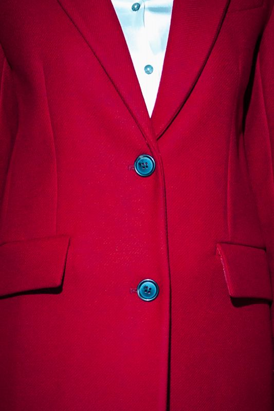 Détails du manteau rouge à deux boutons, un style audacieux.