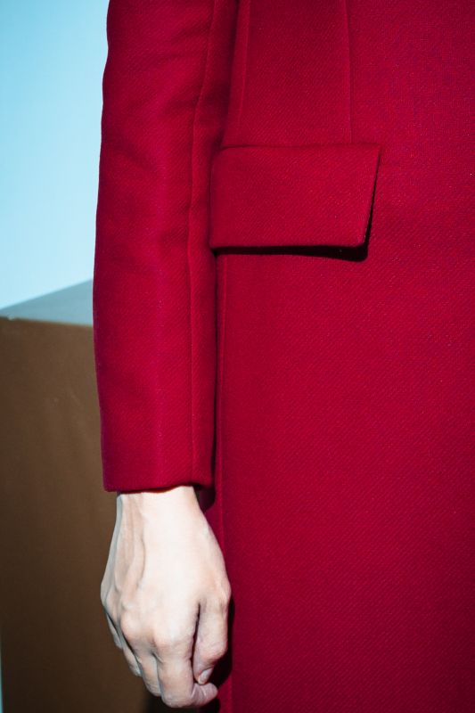 Détails du manteau rouge à deux boutons, un style audacieux.