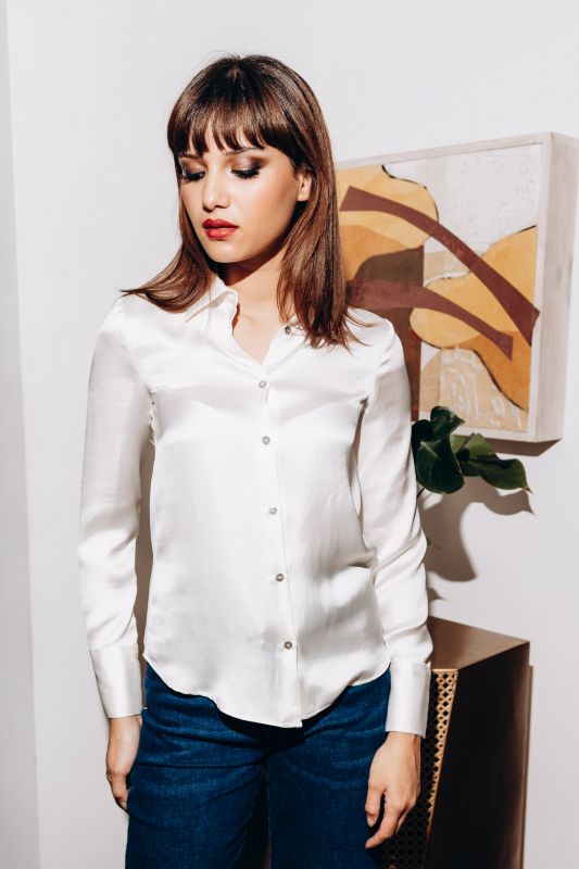 Chemise blanche au fini brillant pour un look chic.