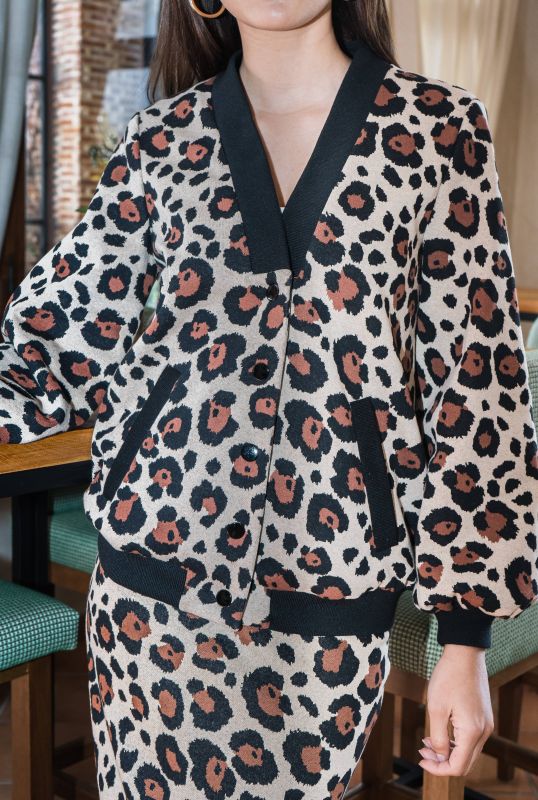 Détails du bomber : Motifs noirs et marron sur fond blanc cassé.