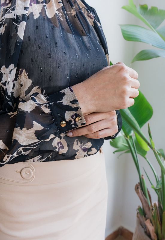 Détails de la blouse imprimée pour femme, mettant en évidence son motif en noir et beige et ses finitions soignées.