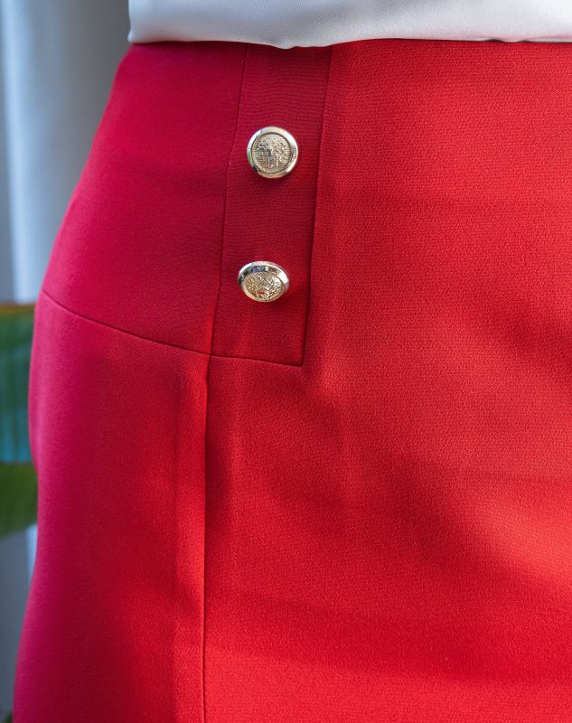 Détails de la jupe : Couleur rouge et boutons dorés.