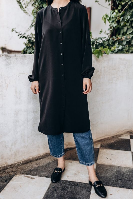 La tunique Louiza noire d'ANAE, collection Ramadan Vibes, portée avec des jeans pour un look moderne et polyvalent.