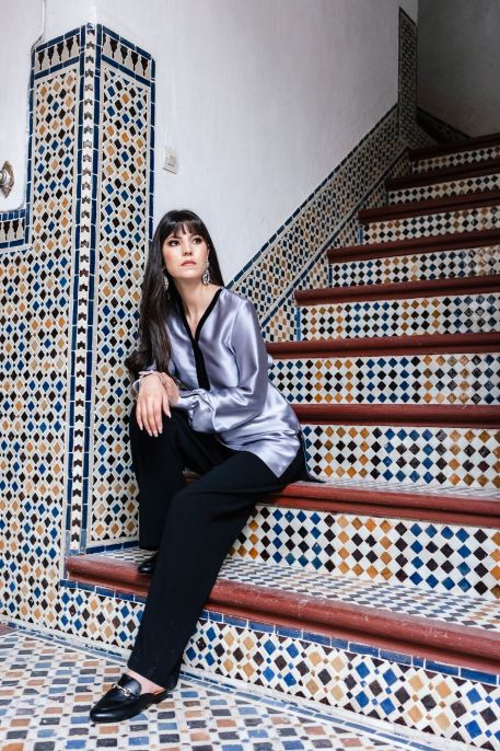 Blouse grise sobre pour femme sur un fond neutre.