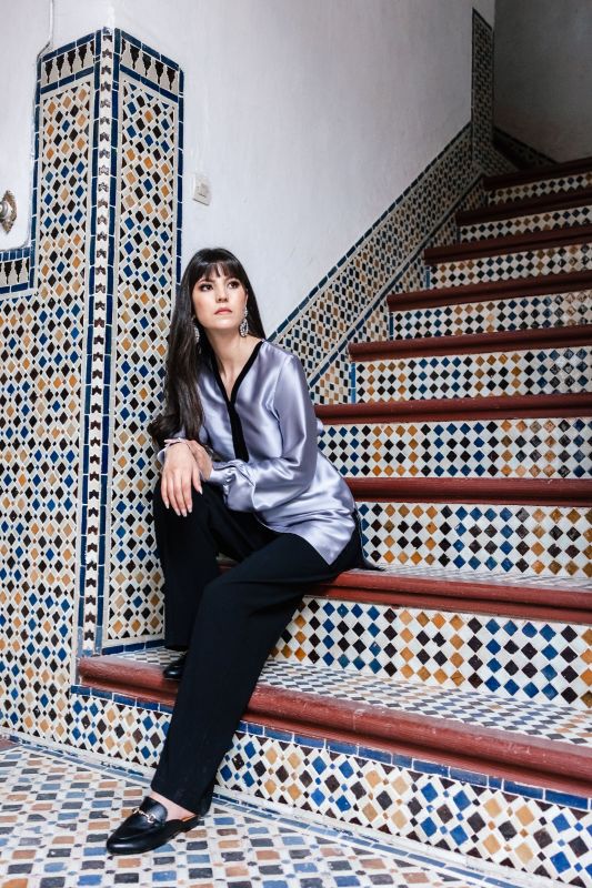 Blouse grise sobre pour femme sur un fond neutre.