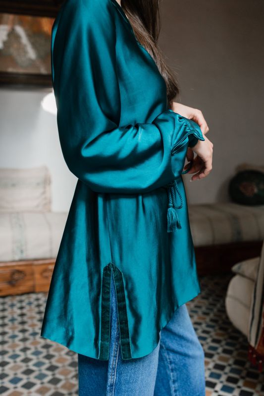 Détails de la blouse vert foncé pour femme, révélant sa nuance riche et ses finitions soignées.