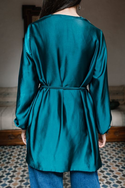 Détails de la blouse vert foncé pour femme, révélant sa nuance riche et ses finitions soignées.