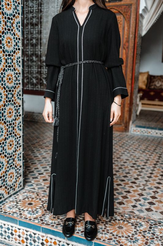 Détails du caftan : Couleur noire et ceinture blanche.