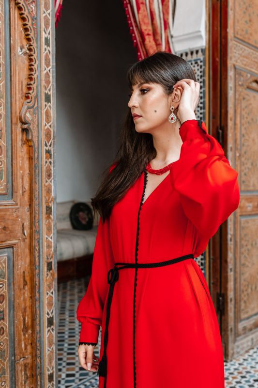 Magnifique caftan rouge accentué par une ceinture noire.
