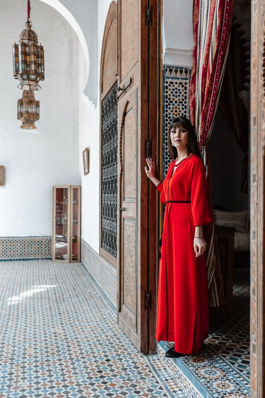 Caftan rouge orné d'une ceinture noire pour un look sophistiqué
