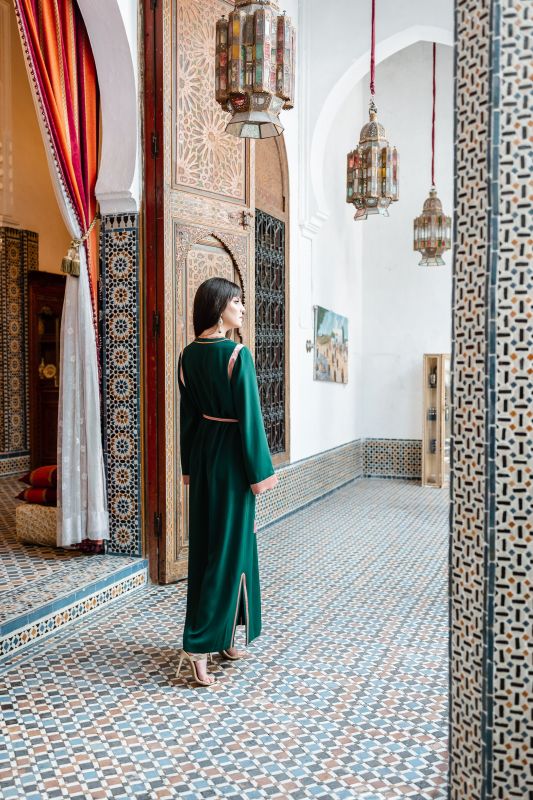 Caftan vert avec une ceinture rose pour une tenue estivale et féminine.
