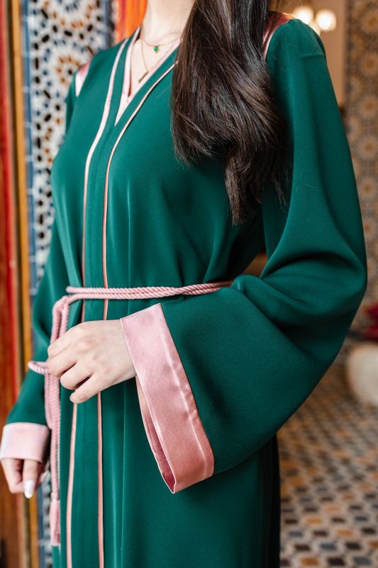 Détails du caftan : Couleur verte et ceinture rose élégante.