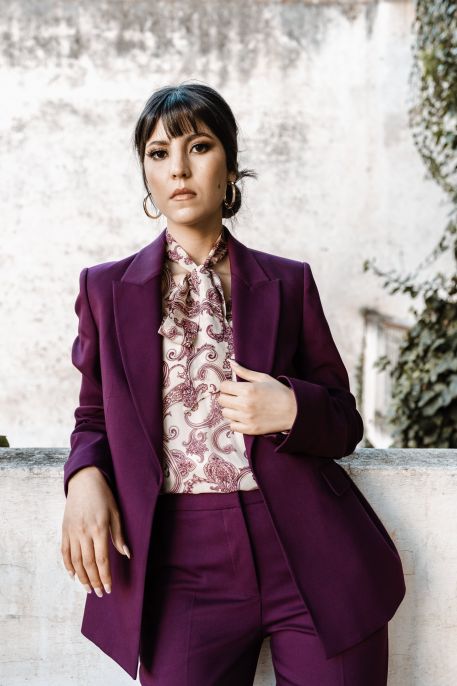 Ensemble élégant : Blouse à motifs de fleurs violet foncé sur fond blanc, associée à une veste.