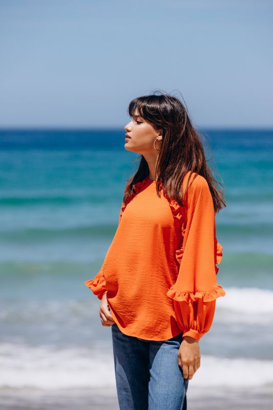 Blouse orange vive pour femme, parfaite pour une touche énergétique.