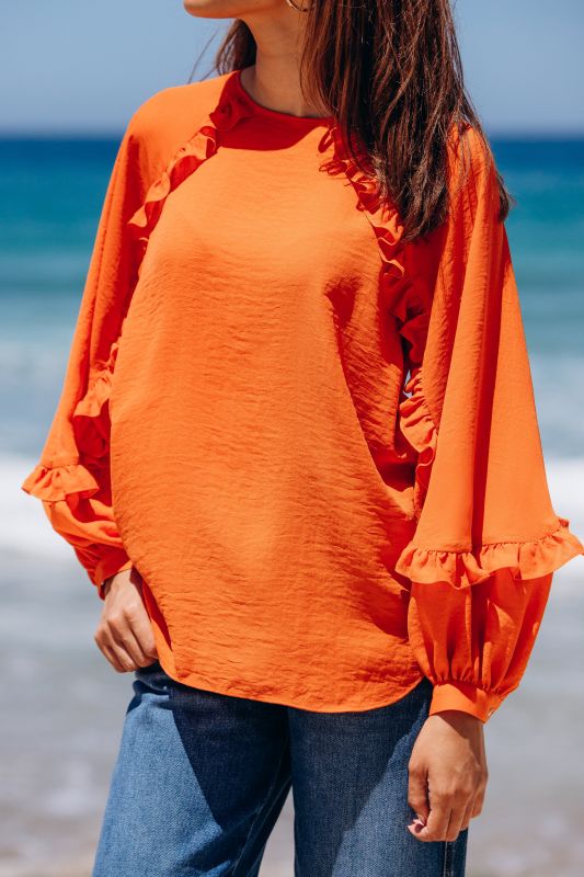 Détails de la blouse orange.