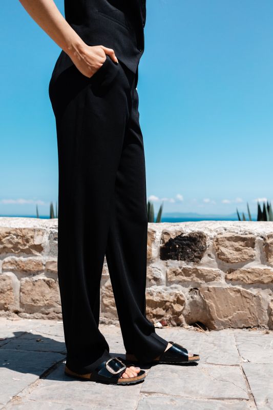 Détails du pantalon noir, une pièce polyvalente et élégante.
