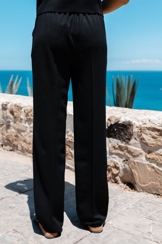 Détails du pantalon noir, une pièce polyvalente et élégante.