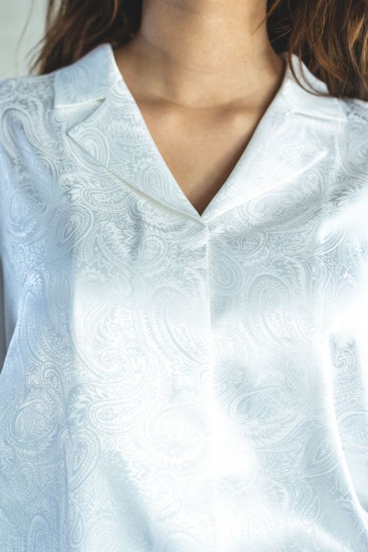 Blouse Georgia blanche, détails floraux subtils, parfait pour un look chic.