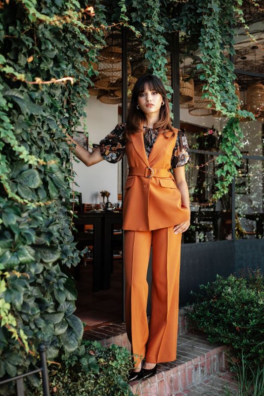 Gilet orange avec ceinture pour une tenue raffinée et ajustée.