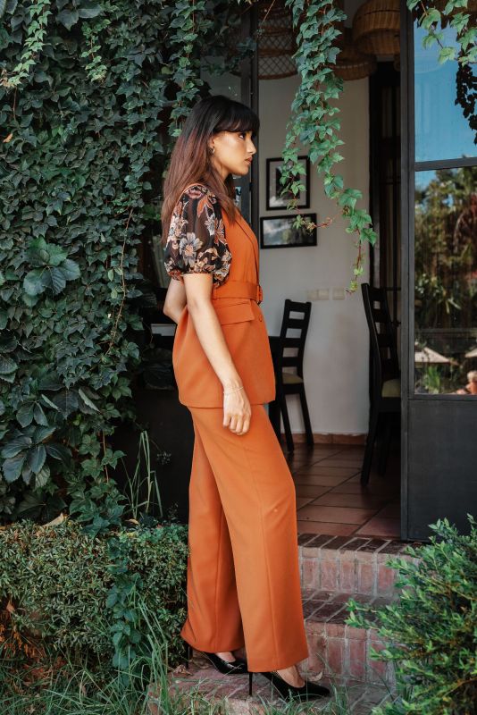 Gilet orange avec ceinture pour une tenue raffinée et ajustée.
