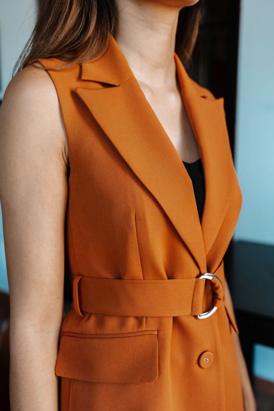 Détails du gilet : Couleur orange et ceinture intégrée.
