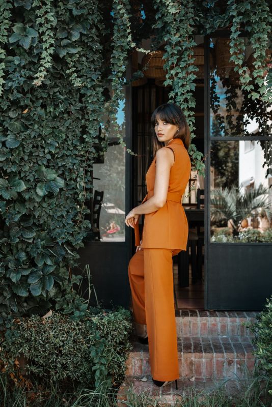 Gilet orange avec ceinture pour une tenue raffinée et ajustée.