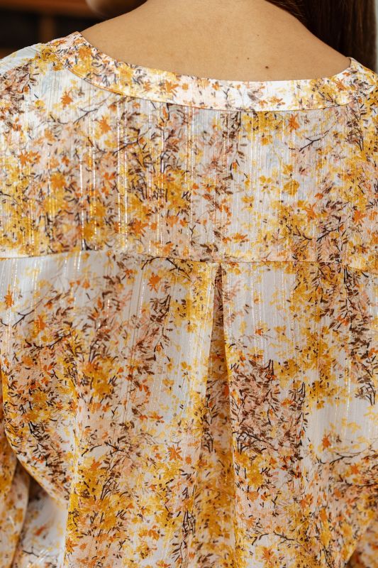 Zoom sur la texture et le tissu de la blouse imprimée, combinant confort et style.