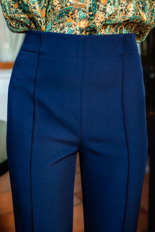 Détail de la fermeture et de la taille du pantalon, alliant design pratique et chic.
