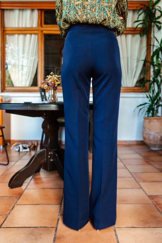 Vue du pantalon bleu marine porté, mettant en avant sa coupe ajustée.