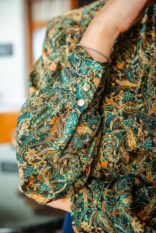 Détail de la BLOUSE CHERYL de la collection Fall 23, mettant en avant le motif vert luxuriant et le design raffiné.