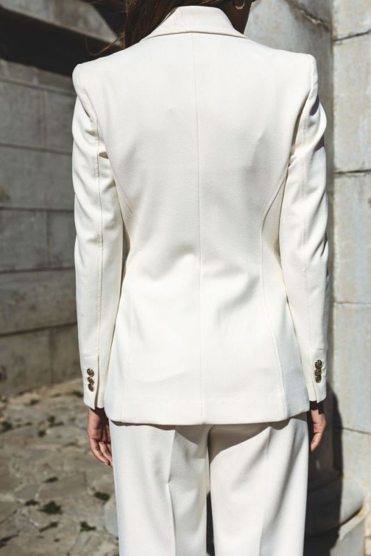 Vue arrière d'un blazer blanc ANAE à la coupe impeccable, reflétant la sophistication moderne.