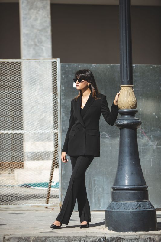 Silhouette féminine en pantalon tailleur noir AARON, coupe ajustée.
