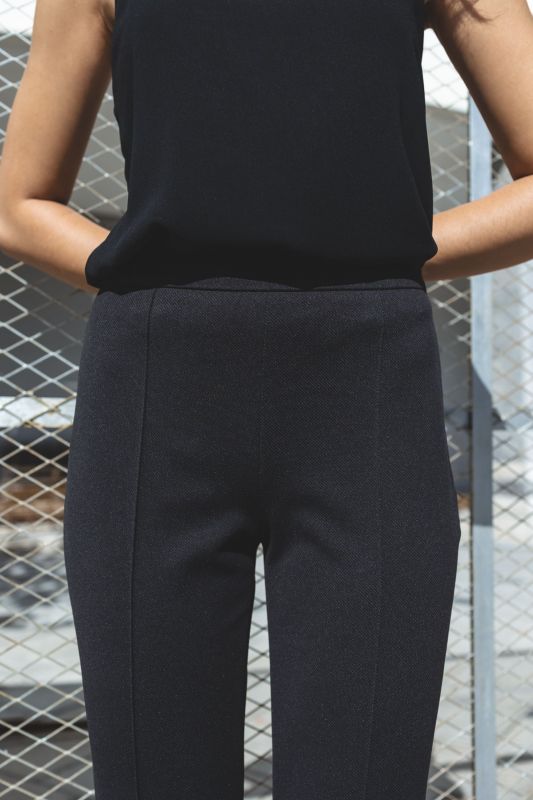 Silhouette féminine en pantalon tailleur noir AARON, coupe ajustée.