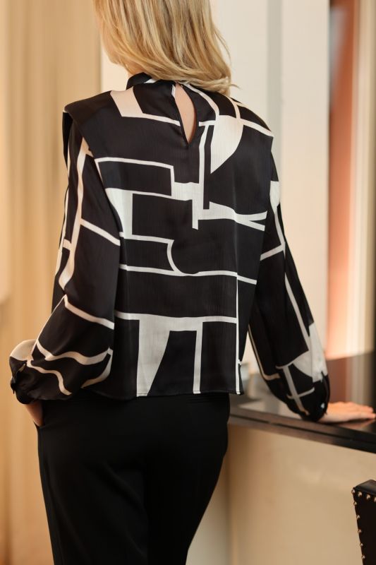 Style avant-gardiste avec la blouse Christy d'ANAE, ses motifs géométriques offrant une touche artistique à une tenue classique.